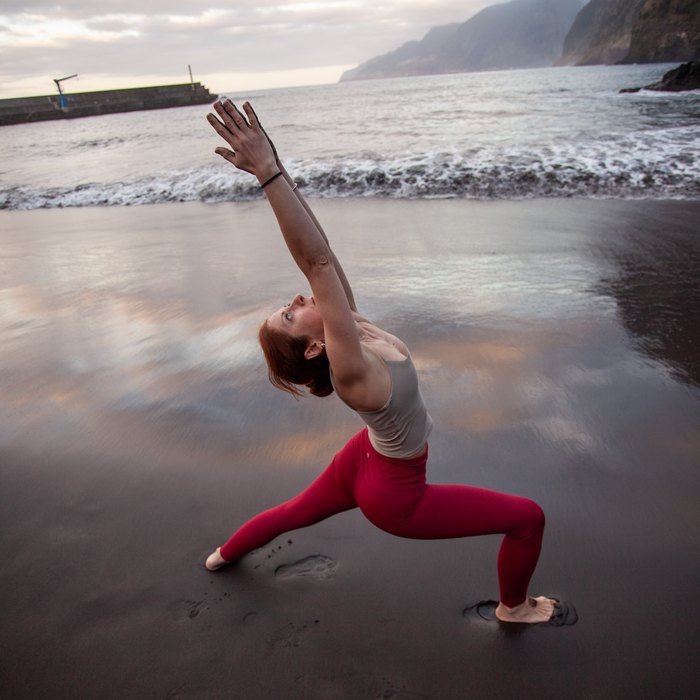 AnnaLisa holding crow pose on a mat on the Madeira coast